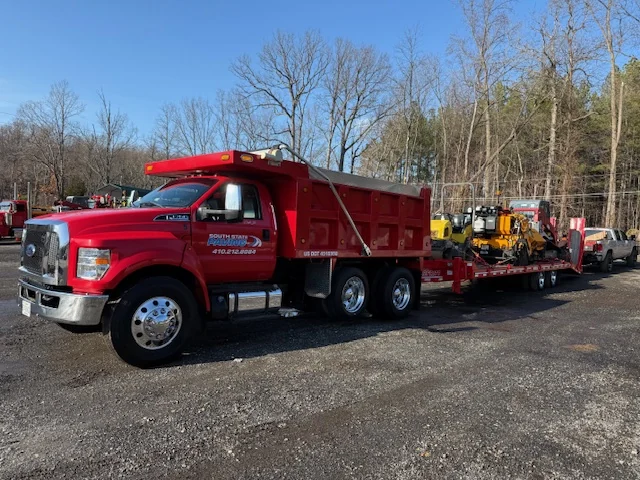 South State Paving dump truck hauling the paver to a job South State Paving dump truck hauling the paver to a job